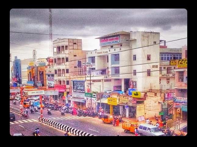 A vibrant street scene in Karur showing shops, traffic, and colorful buildings capturing the town’s daily life