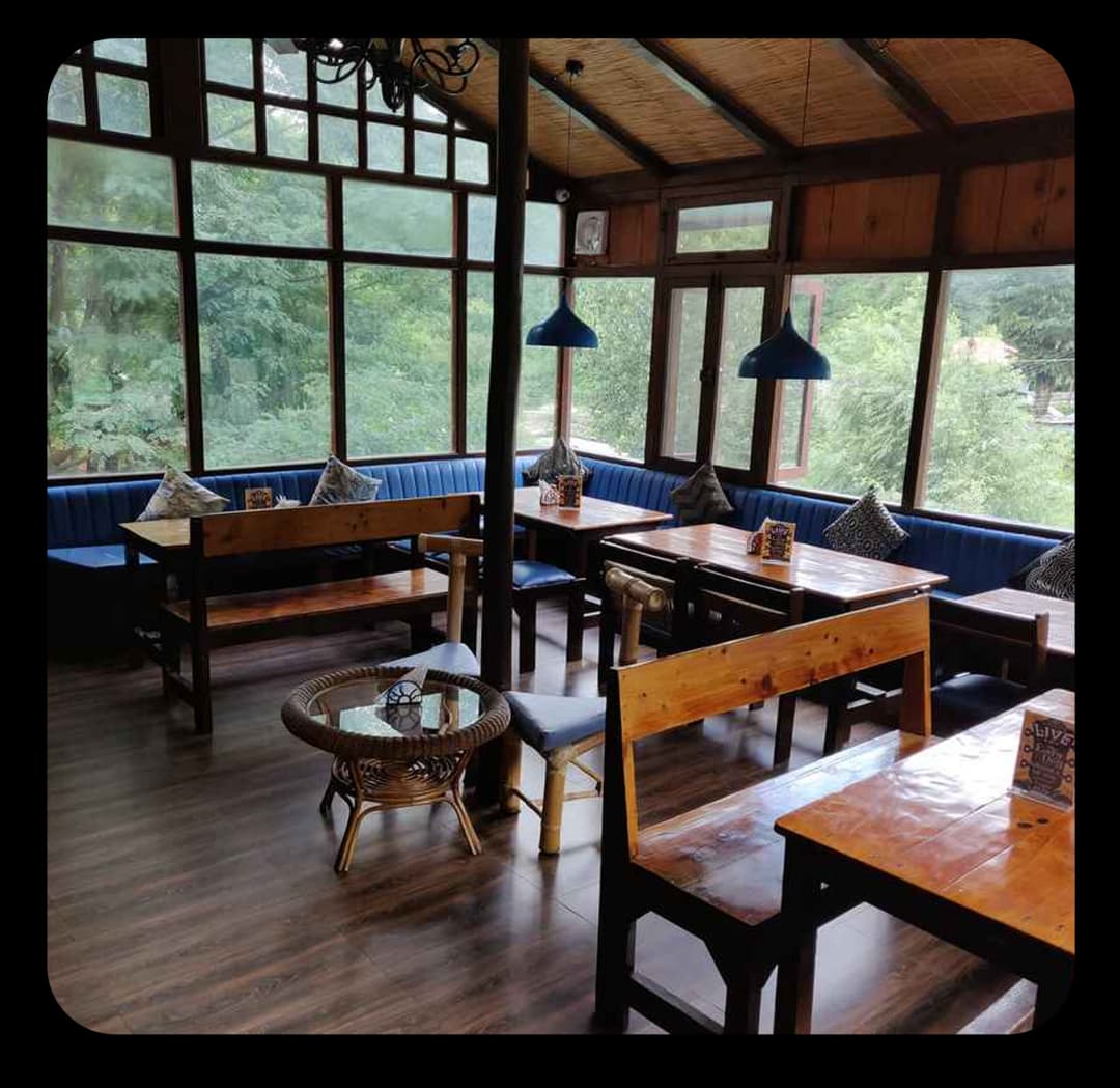 Cozy wooden dining area with large glass windows comfortable seating and peaceful green views outside