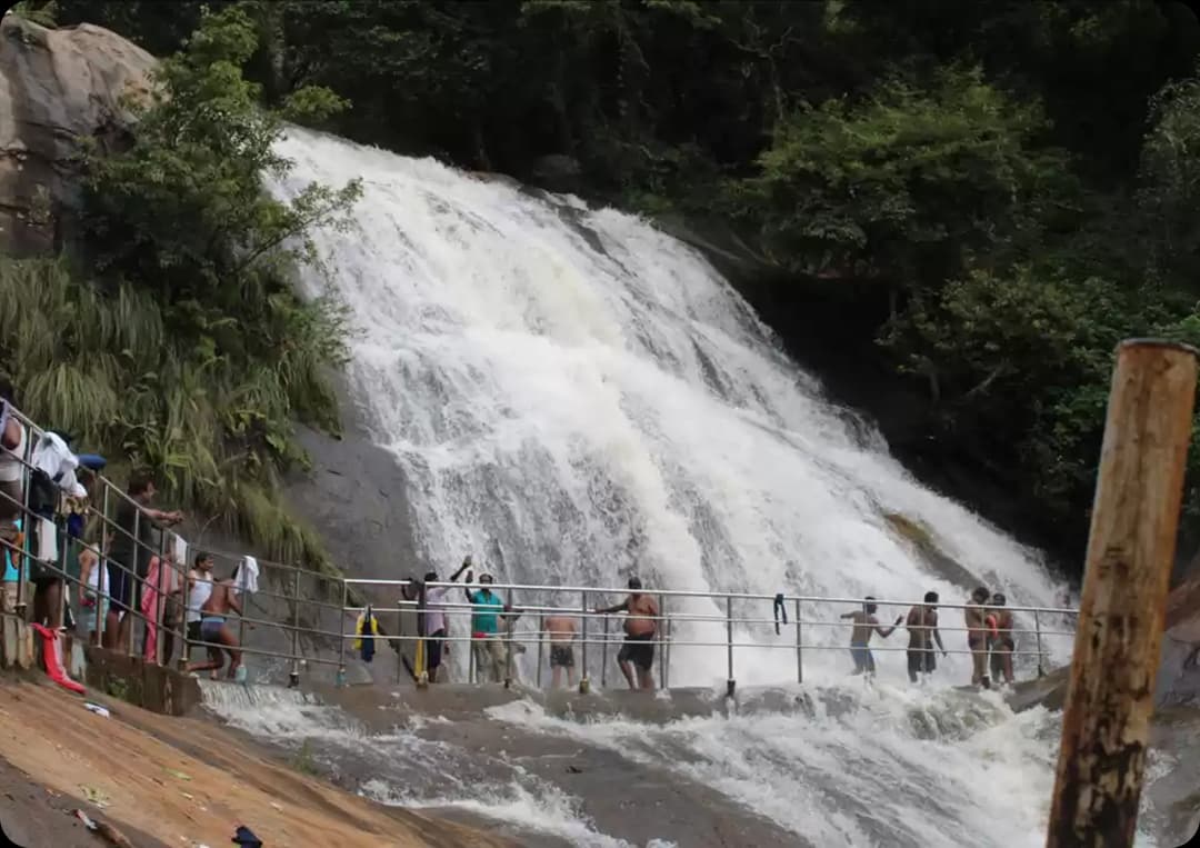 Mini Falls flowing smoothly over wide rocks with visitors enjoying the refreshing scenic spot in Kolli Hills