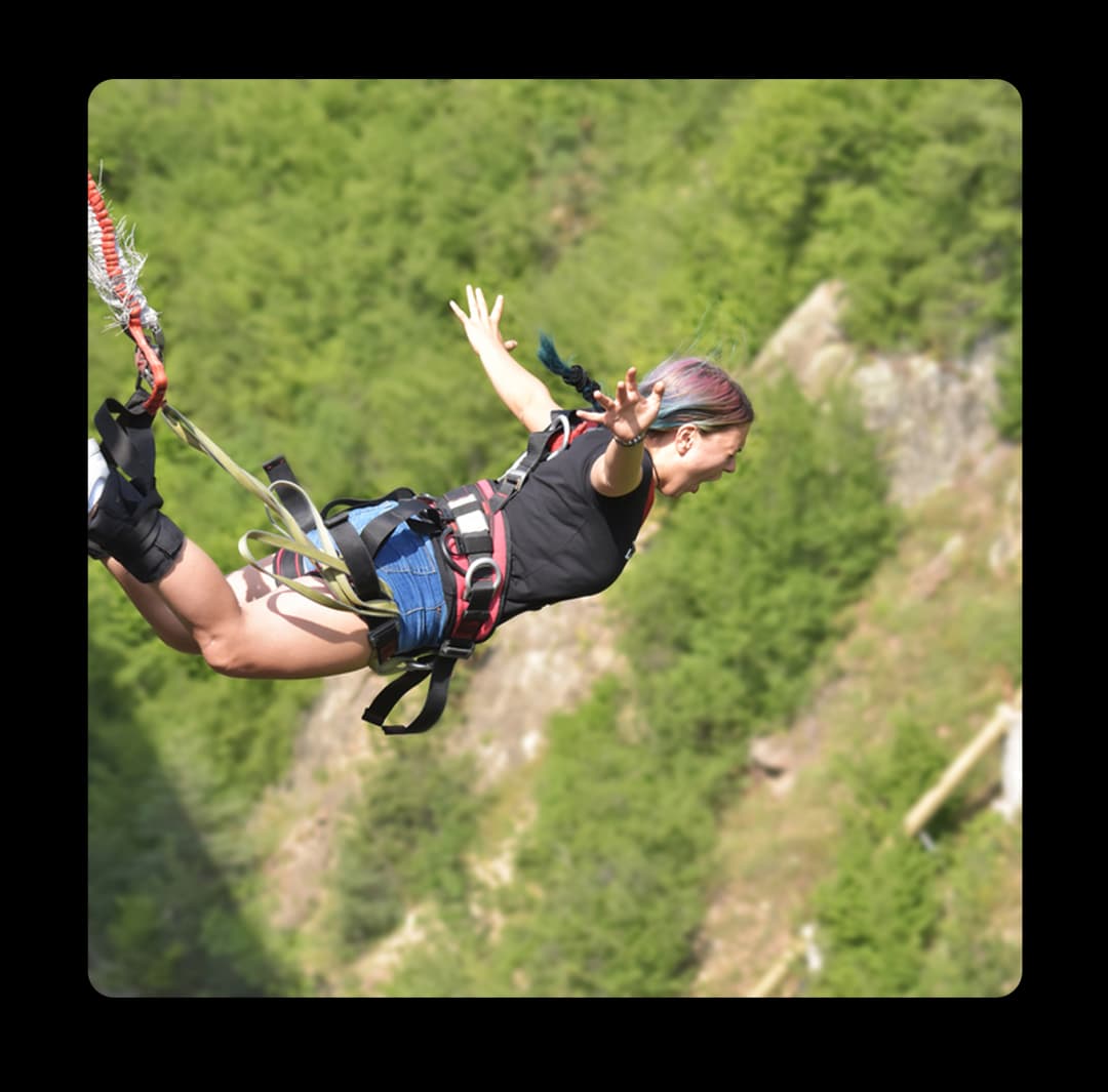 Woman enjoying a thrilling fall jump adventure on a forest cliff of the Kolli Hills