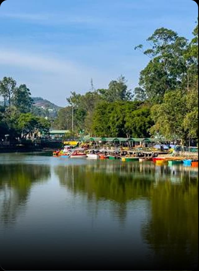 A peaceful lake in Salem with boats, greenery, and hills reflecting in the clear morning water.