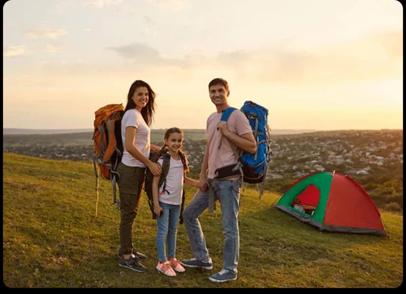 A family of three enjoying an outdoor camping trip at sunset with backpacks and a tent on a hilltop