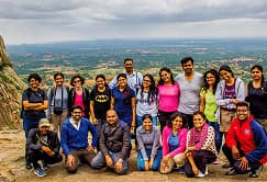Large corporate team posing together at a scenic viewpoint during a company outing at RushCliff.