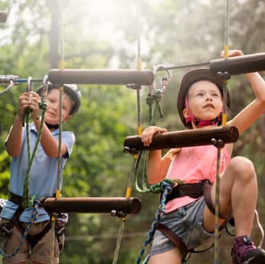 Children enjoying a safe adventure play zone with climbing activities designed for young explorers.