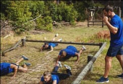 Participants taking part in outdoor obstacle courses and guided hikes designed for team activities.