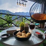 Food and drinks served at an outdoor café offering peaceful seating with stunning hillside scenery.
