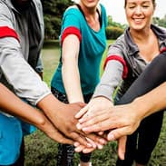 Students joining hands as part of team building tasks that include certificate-based learning options.